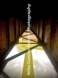 a photo of a bridge with a yellow reflection